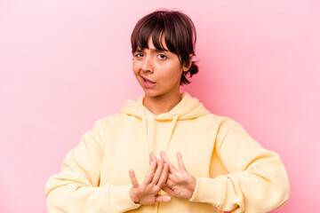 Young hispanic woman isolated on pink background doing a denial gesture