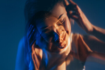 Inner peace. Double exposure face. Positive energy. Defocused silhouette of inspired happy smiling tranquil woman isolated on dark blue out of focus.