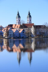 Fototapeta premium Blick auf den Ort Bad Waldsee. Die Türme der Stiftskirche spiegeln sich im Stadtsee