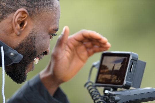 Videographer with black skin checking camera monitor