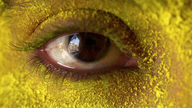 Indian young woman eye smeared with Holi Colors, India