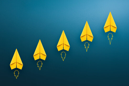 Yellow paper plane on blue background, Success in business growth concept