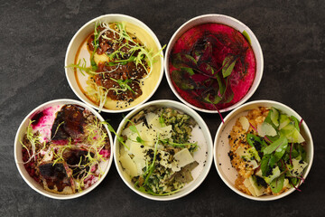 Balanced box diet. Menu suggestions in catering with delivery. Ready healthy food menu in lunch boxes with fish and vegetable packages as daily courier delivery diet plan on black background. 