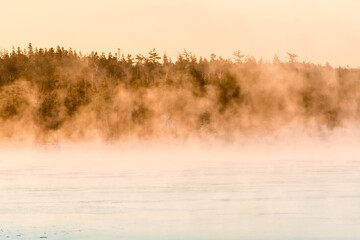Obraz na płótnie Canvas morning fog over frozen sea bed and islands
