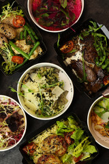 Balanced box diet. Menu suggestions in catering with delivery. Ready healthy food menu in lunch boxes with fish and vegetable packages as daily courier delivery diet plan on black background. 