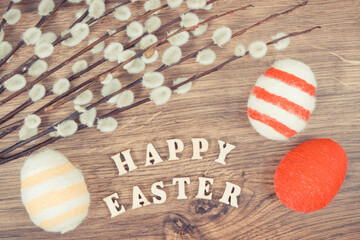 Vintage photo, Inscription Happy Easter, catkins and eggs wrapped woolen string on rustic board, festive decoration