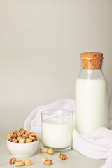 Alternative dairy-free beverage concept with pistachio milk in clear containers and raw pistachios.