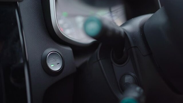 Unrecognizable woman pushing an engine start Botton in an EV car.