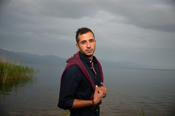 Fashion portrait of young man in black shirt and dark red jumper