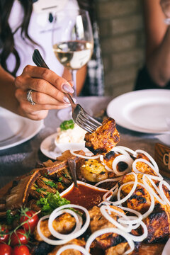 The food is cooked on the grill. Skewers, sauce and salad. A piece of meat on a fork