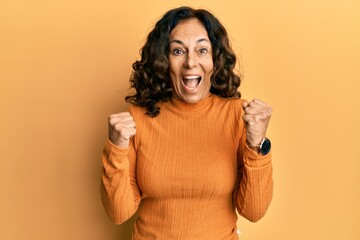 Middle age hispanic woman wearing casual clothes celebrating surprised and amazed for success with...