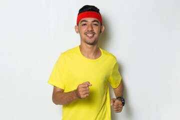 young sporty man dressed in yellow tshirt running on white background
