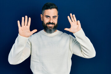 Young hispanic man wearing casual clothes showing and pointing up with fingers number nine while smiling confident and happy.