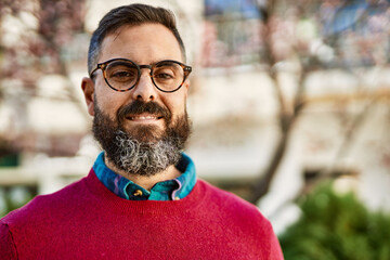 Young hispanic executive man smiling happy standing at the city.