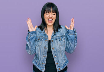 Young hispanic woman wearing casual clothes celebrating mad and crazy for success with arms raised...