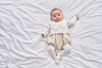 Adorable baby relaxed lying on bed at bedroom