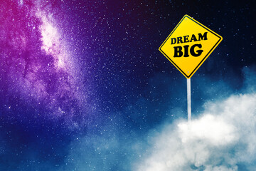 Dream big text on the yellow signpost at night