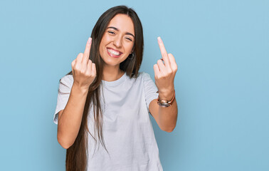 Young hispanic girl wearing casual white t shirt showing middle finger doing fuck you bad...