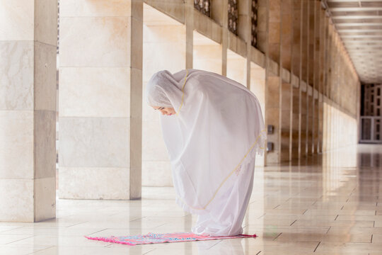 Woman doing Salat with ruku gesture in mosque