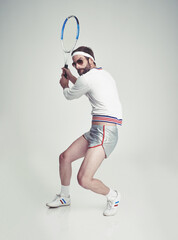 Retro fitness. A young man in the studio wearing tennis gear.