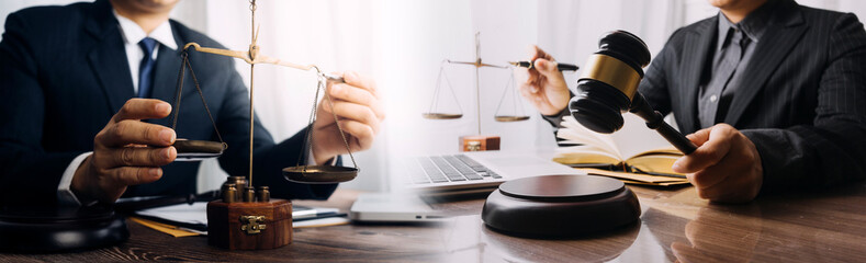 Business and lawyers discussing contract papers with brass scale on desk in office. Law, legal services, advice, justice and law concept picture with film grain effect