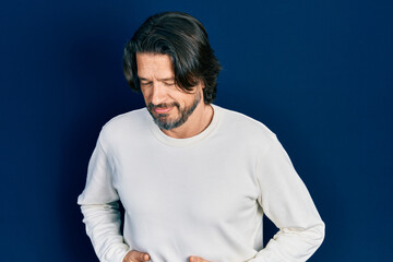 Middle age caucasian man wearing casual clothes with hand on stomach because indigestion, painful illness feeling unwell. ache concept.
