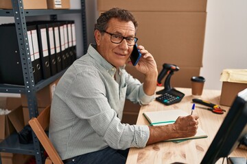 Middle age man ecommerce business worker talking on the smartphone at office