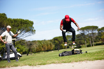 If you think playing is hard try losing. Shot of a frustrated golfer jumping on his golf bag. - Powered by Adobe