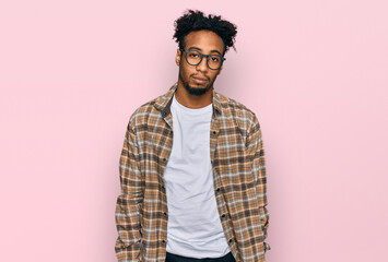 Young african american man with beard wearing casual clothes and glasses looking sleepy and tired, exhausted for fatigue and hangover, lazy eyes in the morning.