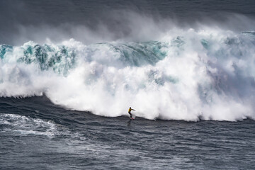 Professional athlete surfing a giant wave.