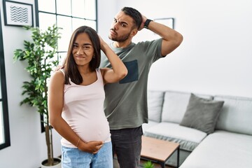 Young interracial couple expecting a baby, touching pregnant belly confuse and wondering about...