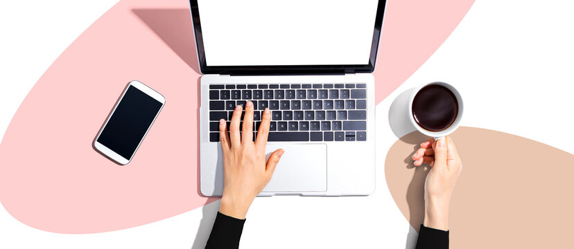 Person using a laptop computer from above - Powered by Adobe