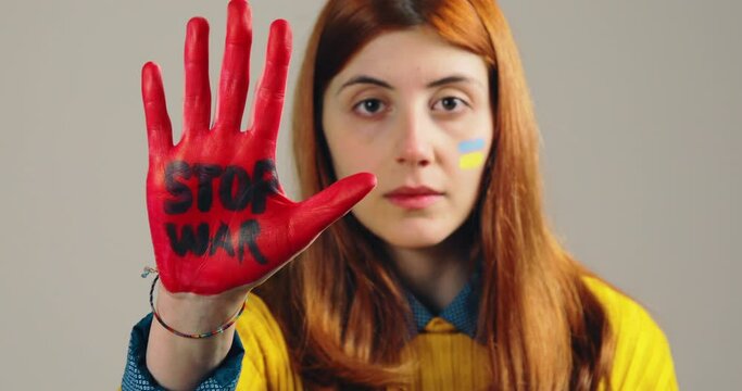 Girl raises her red hand with stop war to stop the horrors in Ukraine