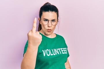 Fototapeta premium Young hispanic woman wearing volunteer t shirt showing middle finger, impolite and rude fuck off expression