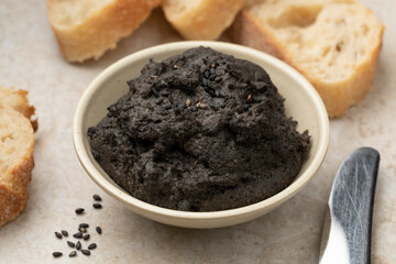 Bowl with fresh made black hummus close up as appetizer 