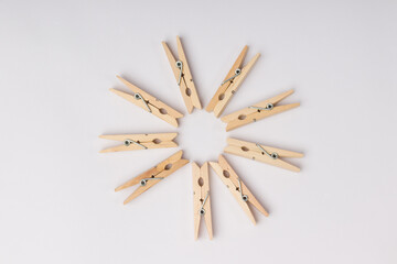 wooden clothespins lie in a circle on a white background