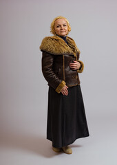 woman posing in winter jacket with fur collar on white background
