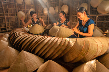 group of vietnamese woman making a traditional conical hat at her home - obrazy, fototapety, plakaty