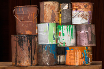 A collection of paint cans, buckets, toxic and hazardous material stacked. Hazardous waste.