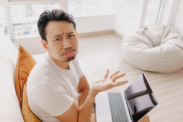 Freelance Asian man sad with the result in his laptop.
