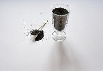Amaranth seeds in a glass with a small spoon.