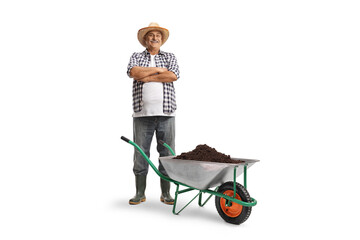 Full length portrait of a mature farmer posing with a wheelbarrow full of soil