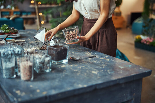 Professional floral designer filling a polyhedron florarium