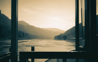 Flussfahrt auf der Elbe in der Sächsischen Schweiz. Blick auf die Elbe Richtung Bad Schandau mit den berühmten Schrammsteinen. Aufgenommen im Hochsommer in freier Natur zwischen Felsen und Sandsteinen