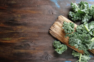 Fresh sliced Italian Kale salad on old wooden board. Dark background. Top view.