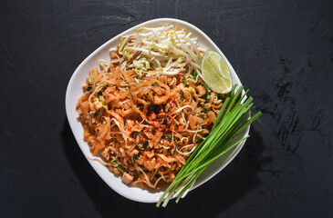 Pad Thai is delicious Thai food. Pat Thai in a plate placed on a black table. Thai noodles. 