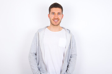 Portrait of successful young caucasian man wearing casual clothes over white background, smiling broadly with self-assured expression. Confidence and business concept.