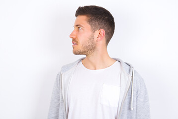 Side view of young happy smiling young caucasian man wearing casual clothes over white background