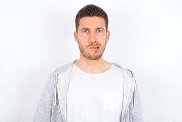 young caucasian man wearing casual clothes over white background being nervous and scared biting lips looking camera with impatient expression, pensive.