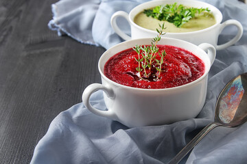 Traditional beetroot soup in white plate with Temyan, sour cream. Dark wooden background. free space text.